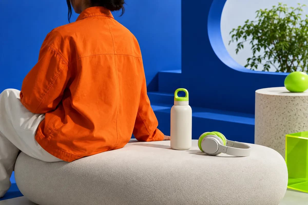 Silhouetted creator in an orange jacket inside a bright blue studio set