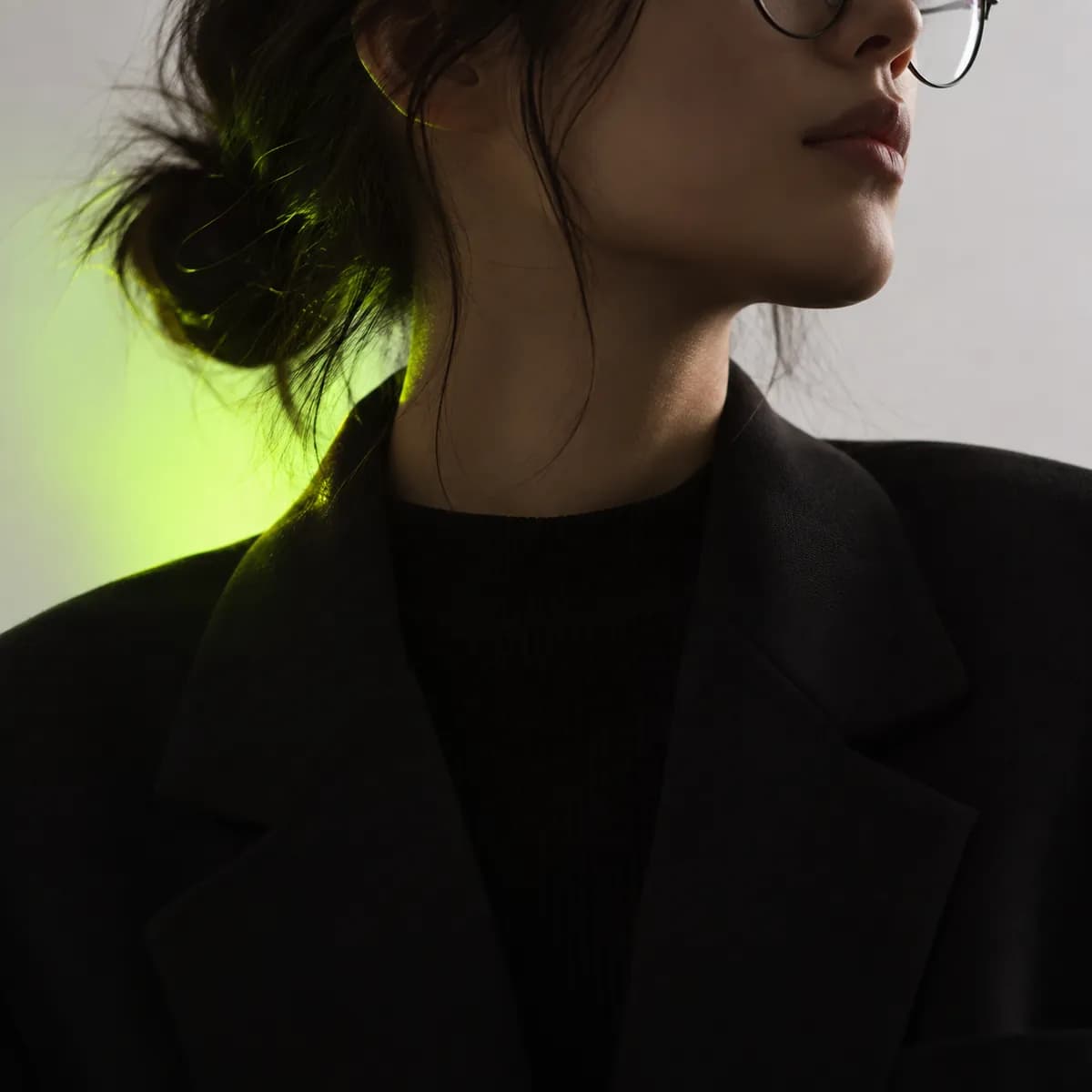 Abstract cropped portrait avatar with round glasses and soft neutral lighting