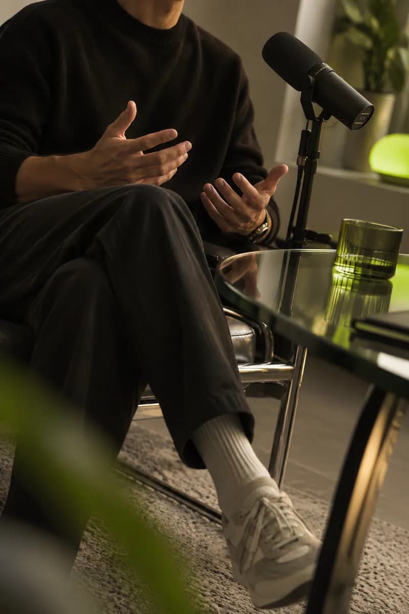 Vertical creative frame showing a speaker cropped below the chin in a softly lit recording studio