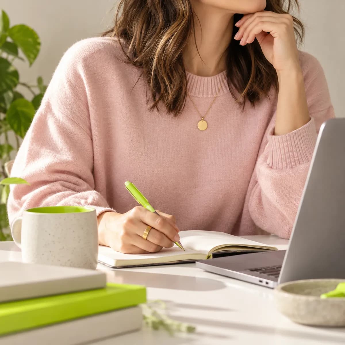 Creator cropped below the chin wearing a pale pink sweater